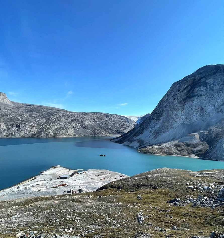 Blick über den Fjord auf die stillgelegte Minenanlage von Maarmorilik mit hellen Abraumhalden